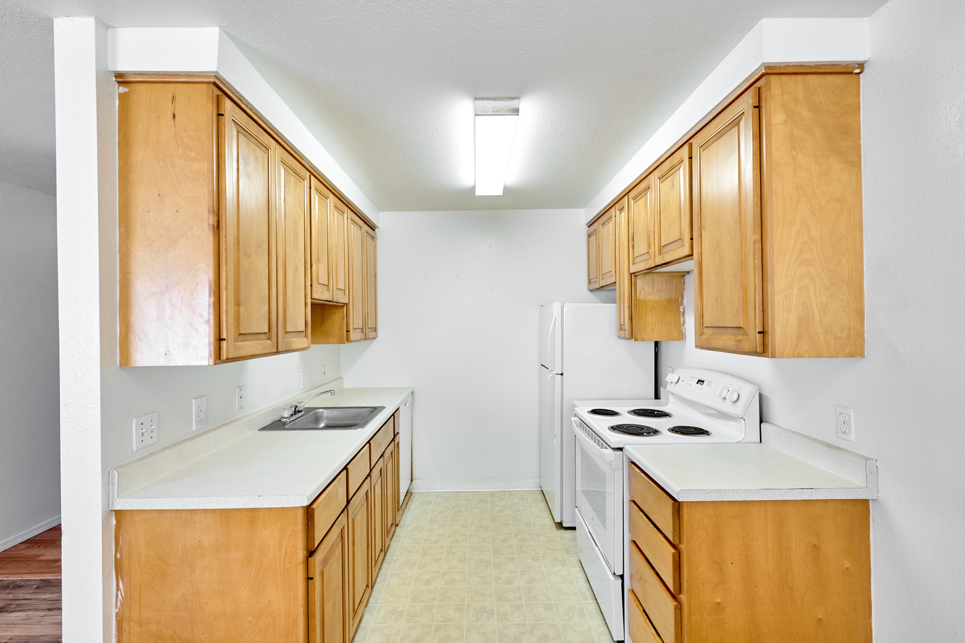 Galley kitchen with full appliance suite including dishwasher